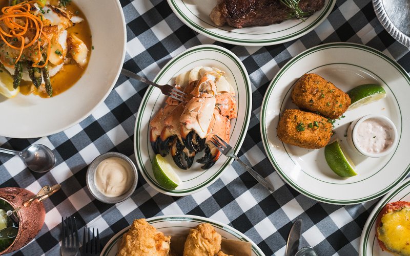 Joe's stone crabs on a beautifully set table, featuring fresh stone crabs, sides, lemon wedges, and dipping sauces