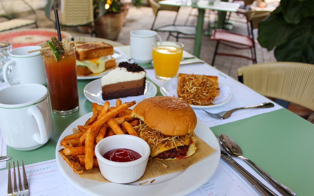 Frita burger with potato sticks shown with french fries and chocolate dessert on the side